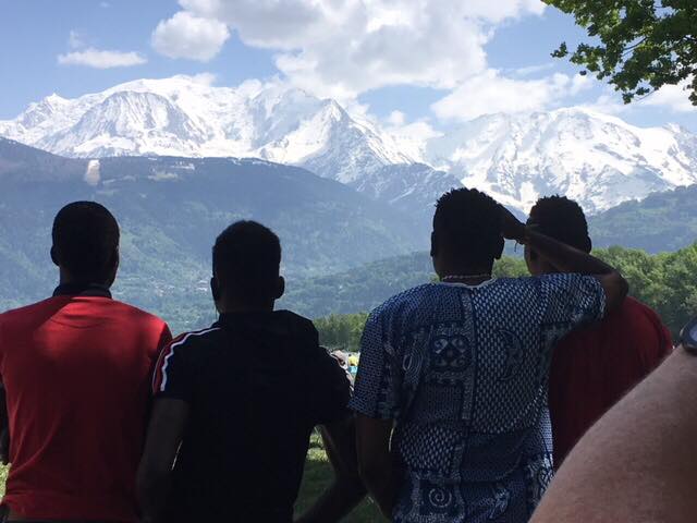 Quatre personnes d'Arve Réfugiés de dos regardent les montagnes enneigées